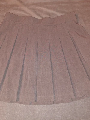 Svart veckad minikjol - Köpte på Zalando. Använd ett fåtal gånger. Mycket bra skick. Storlek XL.  Midjemått: ca 40cm  För frågor skriv gärna!