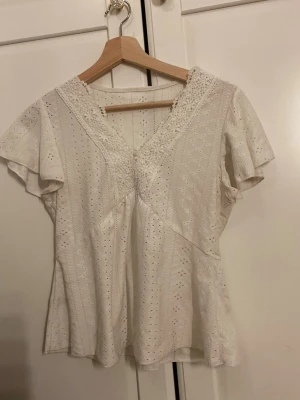 Vit spetsblus  - Söt vit blus med v-ringning och spetsdetaljer använd några gånger 