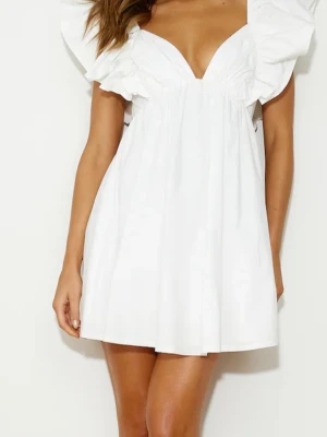 Vit kortklänning med volangärmar - Supersöt vit kortklänning med djup v-ringning och stora volangärmar. Klänningen har en luftig passform och är perfekt för varma dagar. Tillverkad i mjukt bomullstyg som känns skönt mot huden. Enkel men ändå trendig design som sticker ut.