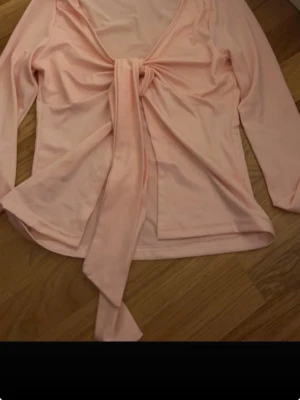 Design by si - Säljer en ljusrosa omlottopp med långa ärmar och knyt framtill. Köpt på vinted då vet ej var den är ifrån men skulle gissa design by si💕