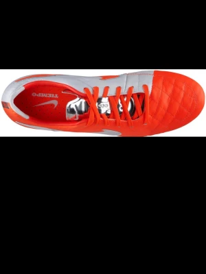 Nike Tiempo orange fotbollsskor - Snygga fotbollsskor från Nike Tiempo-serien i en fräsch orange och vit färgkombination. Skorna har klassisk snörning, quiltad ovandel och greppvänlig sula med fasta dobbar. Perfekta för dig som vill sticka ut på planen och ha bra bollkontroll. Finns ej ute jätte sällsynta 