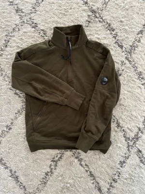 CP Company Half Zip - Jag säljer denna tröjan då den används för lite, tröjan är i mycket gott skick(knappt använd). Tröjan är köpt från Care Of Carl. Storlek M, kan passa S. 