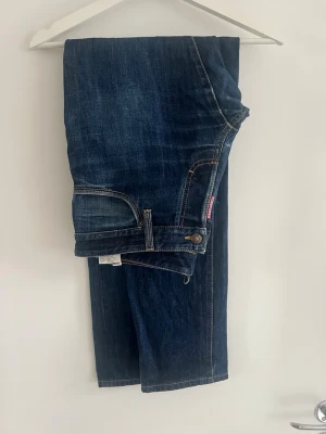 Mörkblå raka jeans från dsquared2 - Säljer ett par klassiska mörkblå jeans från dsquared med raka ben och kontrastsömmar. Jeansen har fem fickor och en snygg tvättad look. Perfekta till en avslappnad stil och passar till det mesta i garderoben.