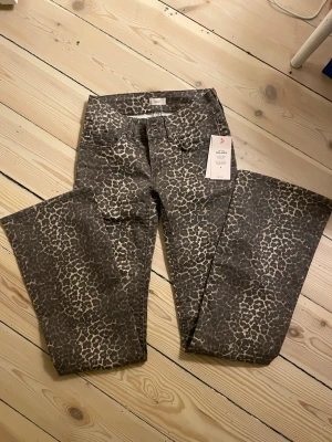 Leopardmönstrade bootcut jeans Nelly - Säljer ett par sjukt snygga bootcut jeans från Nelly i leopardmönster. Modellen är lågmidjade och har en klassisk bootcut passform som ger en cool siluett. Nya med prislapp kvar! OBS: Går ej ner i pris då de är helt nya samt säljs inte längre.