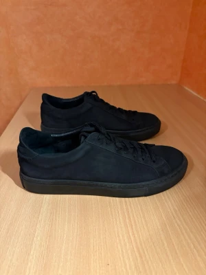 Garment Project mockaskor - Ett par svarta mockaskor från Garment Project i nubuck-läder, storlek 40.  Skorna är väldigt varsamt använda och i princip nyskick. Enda anmärkningen är ett litet snitt vid hälen (vänster sko), syns knappt i verkligheten (se bild).  Butikspris 1800kr  Material: • Överdel: 100% nubuck • Foder/övre foder: 100% läder