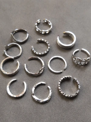 12 st tåringar  - 12 st tåringar med olika former och mönster. Materialet är alloy. (#608)