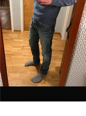 Blå jeans från Nudie Jeans - Säljer ett par snygga blå jeans från Nudie Jeans med schyssta slitningar. Perfekta för en avslappnad och trendig stil. Priset är inte hugget i sten!!! Hör av er vid minsta fundering.
