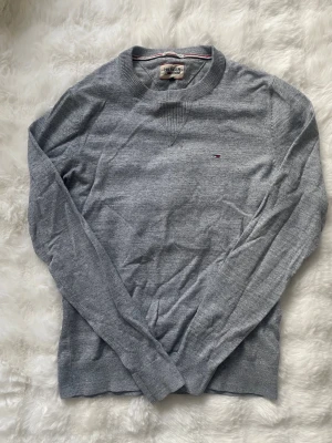 Grå tröja från Hilfiger Denim - Snygg grå tröja från Hilfiger Denim med rund halsringning och diskret logga på bröstet.  Riktigt fin. Storlek S! Pris 79kr! Hör av er vid eventuella frågor! 😊