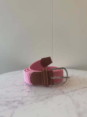 Rosa flätat bälte - Tja säljer helt nytt klassiskt svenskt flätat bälte från Bältgallerian i storlek 105cm i längd och 3,5cm i bredd. Dem är i ett elastiskt material och finns i flera olika färger i min profil.