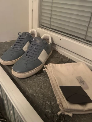 Valentino flycrew  - Snygga sneakers från valentino i blått och vitt läder. Klassisk låg modell med vita sidor och blå ovandel, vita sulor och matchande blå skosnören. Perfekta för dig som gillar stilrena och trendiga skor med premiumkänsla. Möts i Stockholm 