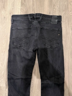 Replay Anbass Hyperflex Jeans Mörkgrå/Svart W32/L32 - Slim Fit - Mycket fint skick. Storlek W32/L32. Mått - Midja: 41,5cm, Ytterbenslängd: 104cm, Benöppning: 15,5cm. Modellen är 185cm & 63kg. Hör av dig vid funderingar!🤝