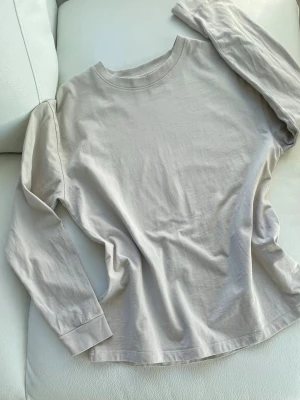 Pull & Bear t-skjorta S - En kittfärgad/greige långärmad T-skjorta från Pull & Bear. En gång använd varefter tvättad med doftfritt tvättmedel, ren och så gott som ny alltså, inga noppor eller missfärgningar. Material 100% bomull, rak boxy modell. Jag har storlek S i nästan allt och tröjan är då skönt relaxed och bra. Tänk till t ex vita shorts eller jeans 🤍🤍 Framdelens mått: • Axelsöm till axelsöm högst upp: 47 cm (oversize modell) • Armhåla till armhåla: 48 cm • Midjans bredd från framdelen: 46 cm • Bredd vid nedre kant