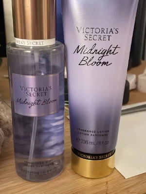Victoria's Secret Midnight Bloom set - Säljer ett Victoria's Secret Midnight Bloom set med en parfymmist och en matchande body lotion. Båda har en snygg lila design med guldiga detaljer och doften är blommig och fräsch. Perfekt för dig som vill dofta gott hela dagen.
