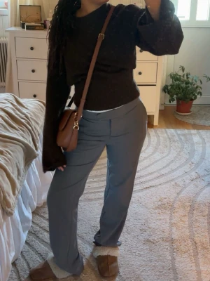 Brun stickad tröja med vida ärmar - Mysig brun stickad tröja med breda, långa trumpetärmar och rund hals. Från Gina Trocot! Tröjan är croppad och har en figurnära passform i midjan.