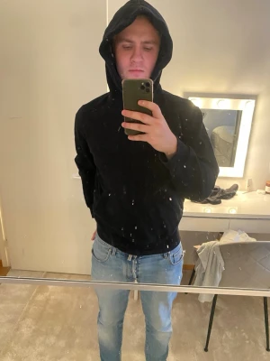 Svart hoodie med klassisk passform - Säljer en svart hoodie med klassisk passform och stor huva. Hoodien har ribbade muddar vid ärmslut och nederkant samt en stor ficka framtill. Perfekt för dig som gillar en enkel och stilren look. Märke: Weekday Storlek: S