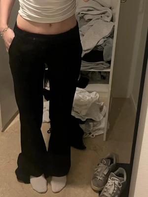 Svarta Lågmidjade kostymbyxor bikbok  - Säljer ett par svarta bootcut byxor med låg midja. Byxorna har en klassisk passform och är perfekta för dig som gillar en tidlös och enkel stil. Materialet känns mjukt och följsamt, vilket gör dem bekväma att bära hela dagen. Storlek 34 passar mig i längden som är 170, lite stora i midjan 
