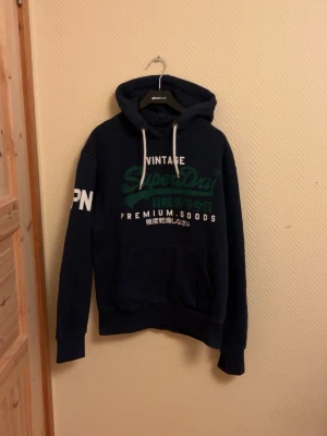 Vintage Superdry Hoodie  - En lite schysstare Vintage Superdry Hoodie! I väldigt bra skick skulle säga 9/10 Storlek L 🙌       Skriv vid mera frågor/bilder 🤩                                   Fraktar inom 24 Timmar 🚚