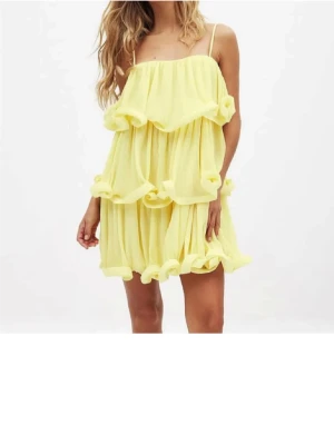  volangklänning från NA-KD x Lojsan Wallin - Säljer en kort gul klänning med flera lager volanger och tunna axelband. Klänningen har en luftig och flowy design som ger ett lekfullt intryck. Perfekt för varma dagar och somriga tillfällen. Endast använd en gång 🥹🥹❣️