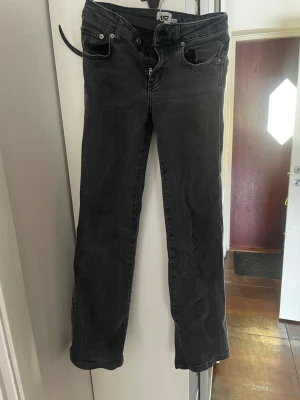 Mörkgrå/ svarta jeans - Fina mörka flared jeans med knappfickor på baksidan. Jeansen är köpta på lager 157 och är i storlek xs.  