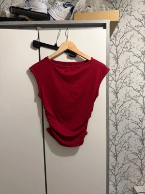 Mörkröd ärmlös topp - En enkel och snygg mörkröd topp med ärmlös design och rund halsringning. Perfekt att matcha med jeans eller kjol för en cool look. Materialet känns mjukt och lätt, vilket gör den bekväm att bära hela dagen.