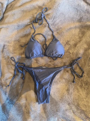 Mörkblått bikinisett - Jättefint mörkblått bikinisett från SHEIN. Knytning i halsen och runt bysten samt uttagbar vaddering. Låg/medelhög midja på bikinitrosorna. 