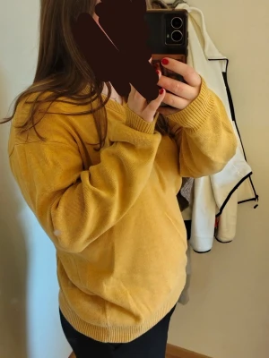 Gul stickad tröja med v-ringning - Mysig gul stickad tröja med v-ringad hals och ribbade muddar vid ärmslut och nederkant. Tröjan har en avslappnad passform och är perfekt för lager på lager. Passar dig som gillar en enkel men trendig stil. Storlek XL men är snygg som oversized på mig som har M.  