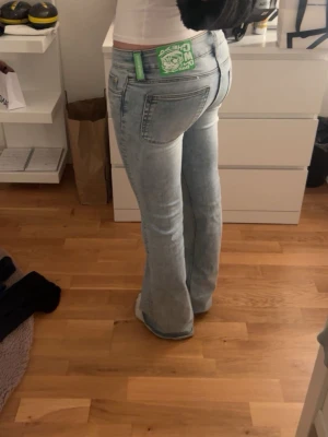 Cheap Monday jeans - Säljer ett par ljusblå bootcut-jeans från Cheap Monday med en grön logga på bakfickan. Jeansen har låg midja och utsvängda ben.Använda ca 5 gånger jätte bra skick men fåtal slitningar längst ner.(bild)                     Storlek- 28/32