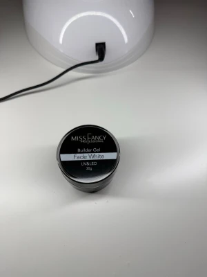 Miss Fancy Builder & Fiber Gel 30g - Två burkar nagelgel från Miss Fancy, en builder in a bottle: en Builder Gel i färgen Fade White och en Fiber Gel i Clear. Även BIABen är i clear. Alla är UV&LED-härdande och kommer i 30g burkar/15ml flaska. Perfekt för att bygga och förstärka naglar med naturligt resultat. Helt nya, oöppnade. Nypris 329kr samt ca 199kr Köpes tillsammans alternativt var för sig