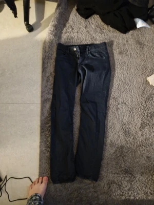 Mörkblå raka jeans - Snygga mörkblå jeans med rak passform och klassisk femficksdesign. Jeansen har knappgylf och är tillverkade i ett denimtyg som ger en tidlös look. Perfekta för dig som gillar enkel och stilren stil.