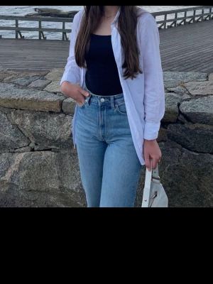 Vit oversized skjorta i bomull - Klassisk vit skjorta i oversized modell med långa ärmar och knappar framtill. Tillverkad i mjuk bomull som ger en avslappnad och trendig look.