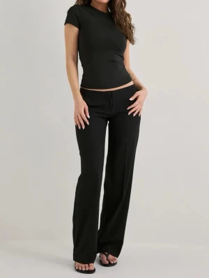 Svarta lågmidjade kostymbyxor från Nelly  - Snygga svarta jeans med låg midja och raka ben. Jeansen har en minimalistisk design utan synliga detaljer och sitter avslappnat över höfterna. Perfekta för en stilren och trendig look.