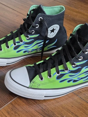 Converse All Star flames high tops - Säljer ett par Converse Chuck Taylor All Star Black Green Flame. Rena och fina.
