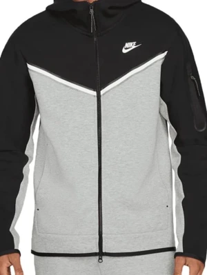 Nike Tech Fleece  - Nike Tech Fleece hoodie med dragkedja i svart och grått. Hoodien har en vit Nike-logga på bröstet, huva och en praktisk ficka med dragkedja på ärmen. Tillverkad i mjukt och bekvämt fleecematerial. Snygg kontrastdesign med vita detaljer.