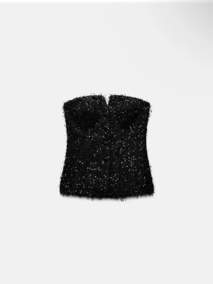 Svart glittrig tubtopp från Zara - Supersnygg svart tubtopp från Zara med glittriga detaljer och fluffig textur. Toppen är axelbandslös och har en lätt hjärtformad urringning. Perfekt för att sticka ut och skapa en trendig look.