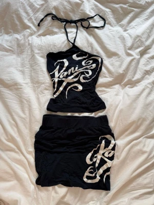 Tvådelat Y2K set från Karl Kani - Säljer ett tvådelat set med topp och kjol från från Karl Kani med vit grafisk logga framtill. De är svårt att se färgen på bilden, men den är väldigt mörkblå / nästan svart! 