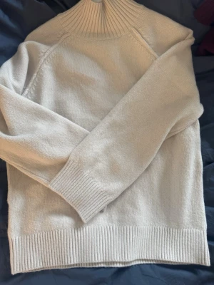 Stickadtröja med höghals  - Fin beige stickad tröja ifrån HM med hög hals. Tröjan har aldrig använt utan bara hängt i garderoben. Köpte för ca ett halvår sen för 300kr. Storlek XS men är ganska stor och skulle passa S