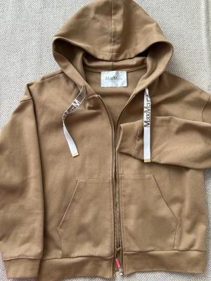 Max Mara Beige loungewear-set  - Mysigt loungewear-set från MaxMara i beige bomull. Setet består av en hoodie med dragkedja, fickor och vita snören med logga samt en matchande t-shirtklänning med samma snördetalj. Perfekt för chill dagar hemma. Storlek XL passar även S M L Köpt i Japan för 4500kr på vintage.