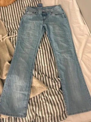 Ljusblå bootcut jeans  - Säljer ett par ljusblå bootcut jeans med klassisk femficksdesign och dragkedjegylf. Jeansen har en lätt utsvängd passform och är tillverkade i mjukt denimtyg. Perfekta för en avslappnad och trendig look. Säljer då dom tyvärr inte passar mig. 