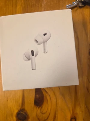 Apple AirPods Pro trådlösa hörlurar - Säljer ett par vita Apple AirPods Pro med laddningsetui. De är in-ear, har silikonproppar och den klassiska stilrena Apple-designen. Perfekta för dig som vill ha brusreducering och grymt ljud i ett smidigt format. Laddas enkelt i det medföljande etuiet.