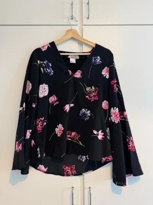 Blommig blus - Mycket fin blus med vida ärmar och v-ringning. Har tyvärr inte fått så många tillfällen att använda den på, varav jag säljer den.