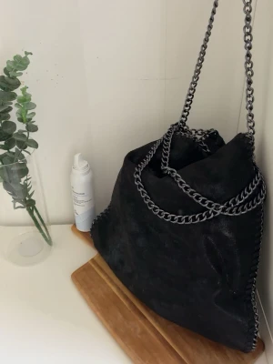 Svart axelväska - Snygg svart axelväska .Väskan har en mjuk, något glansig yta och rymlig form, JÄTTE SNYGG och får plats med mycket grejer och typ aldrig använd🐦‍⬛