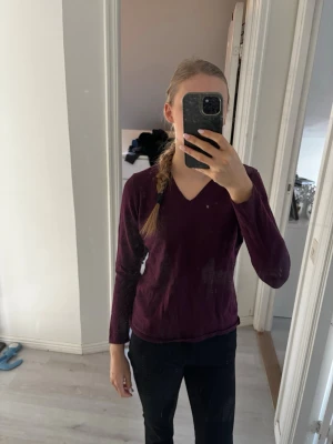 Vinröd V-ringad långärmad tröja -  Vinröd finstickad långärmad tröja med V-ringning. Tröjan har en enkel och stilren design, perfekt att matcha med jeans eller kjol. Xs/s