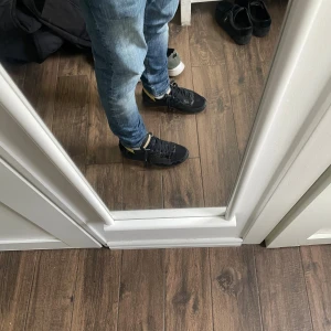 Svarta sneakers med gummisula - Säljer ett par svarta sneakers med klassisk design och snörning. Skorna har en ljusbrun gummisula med fiskbensmönster och detaljer i beige vid plösen. Perfekta för dig som gillar en clean och stilren look till vardags. Några skador, sulorna har gått sönder 