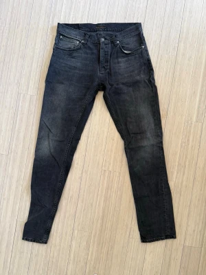 Svarta slim fit jeans från Nudie - Svarta slim fit jeans från nudie. I princip helt nya och har storlek w33/L34. För fler frågor eller intresse för fler bilder är det bara att höra av sig🤠