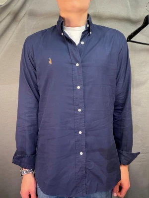 Ralph Lauren skjorta - Säljer denna sjukt snygga ralph lauren skjortan perfekt för sommaren! Den är size S. Modellen är 180cm. Skjortan kan passa upp till 186! Skick 8/10 inga hål eller skador. Nypris ca 1599kr. Hör av dig vid minsta fundering! Köp gärna med postnord🤩📦