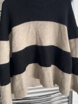 Stickad tröja - Randig svart beige stickad tröja. Knappt använd💕.