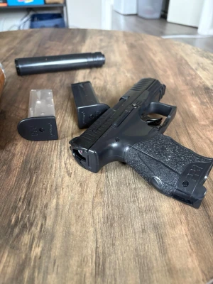 Airsoftpistol svart med magasin och BB-kulor - Säljer en svart airsoftpistol med två magasin, ljuddämpare och en flaska med 2700 st 6 mm vita BB-kulor (0,20 g) halva flaskan kvar. Pistolen har greppvänligt handtag och modern design. Perfekt för airsoftspel och träningpistolen är lite sönder men går fortfarande o skjuta med. Nypris 800.