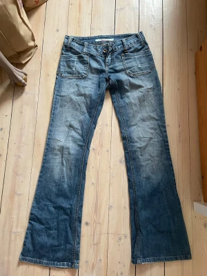 Blå bootcut jeans från ONLY - Säljer ett par supersnygga blå bootcut jeans från only med coola fickor och snygga detaljer. Gamla favoriter i mycket bra skick som tyvärr har blivit för små för mig… köpta i Köpenhamn, jeansen har coola fram och bak -fickor, bälteshällor och knappgylf. Perfekta med både klackar och sneakers för en avslappnad och trendig look! Skickar snabbt och skriv vid intresse eller för en snabb affär💕✨