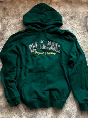 GAP Classic hoodie - Mörkgrön hoodie från GAP Classic med broderad text på bröstet. 🖤