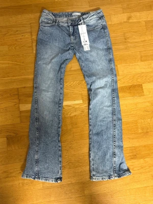 Blå bootcut jeans från Gina - Säljer ett par ljusblå bootcut jeans från Gina Tricot modell 'Perfect Jeans Twisted Bootcut' i strl 36. Ej använd 
